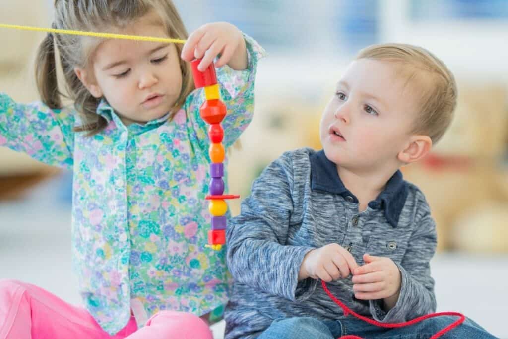 what is loose parts play two toddlers play with loose beads and strings