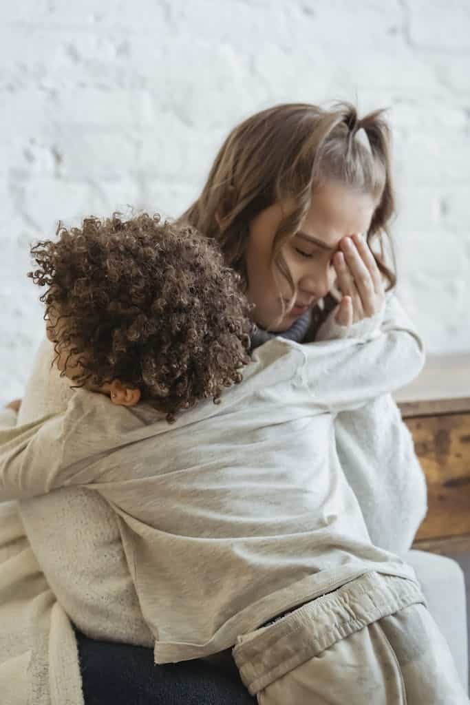 Mother and son share a heartfelt hug during a moment of emotional connection indoors.